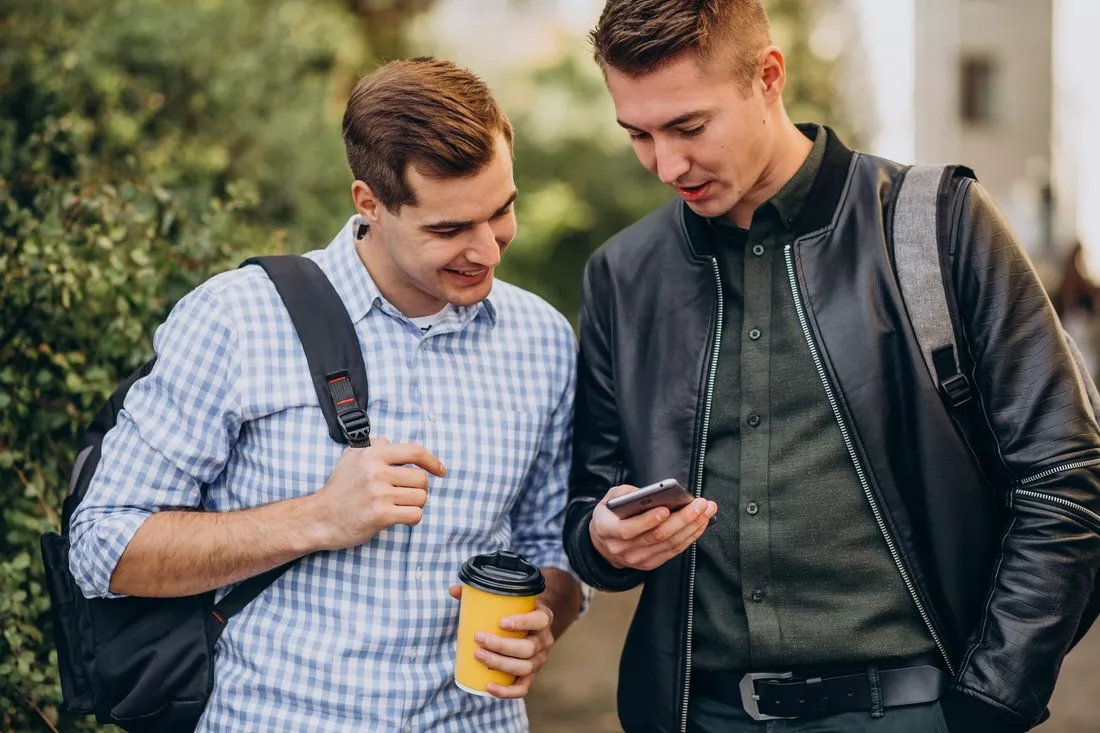Dwaj studenci sprawdzają coś w telefonie