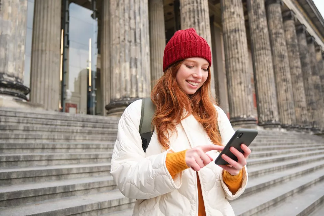 Studentka w podróży korzysta z aplikacji w telefonie